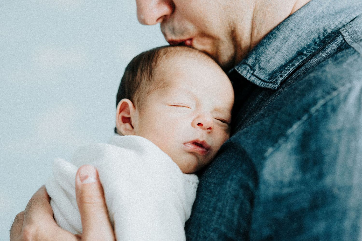 Close-up shots show tender moments between parents and their sleeping newborn baby.