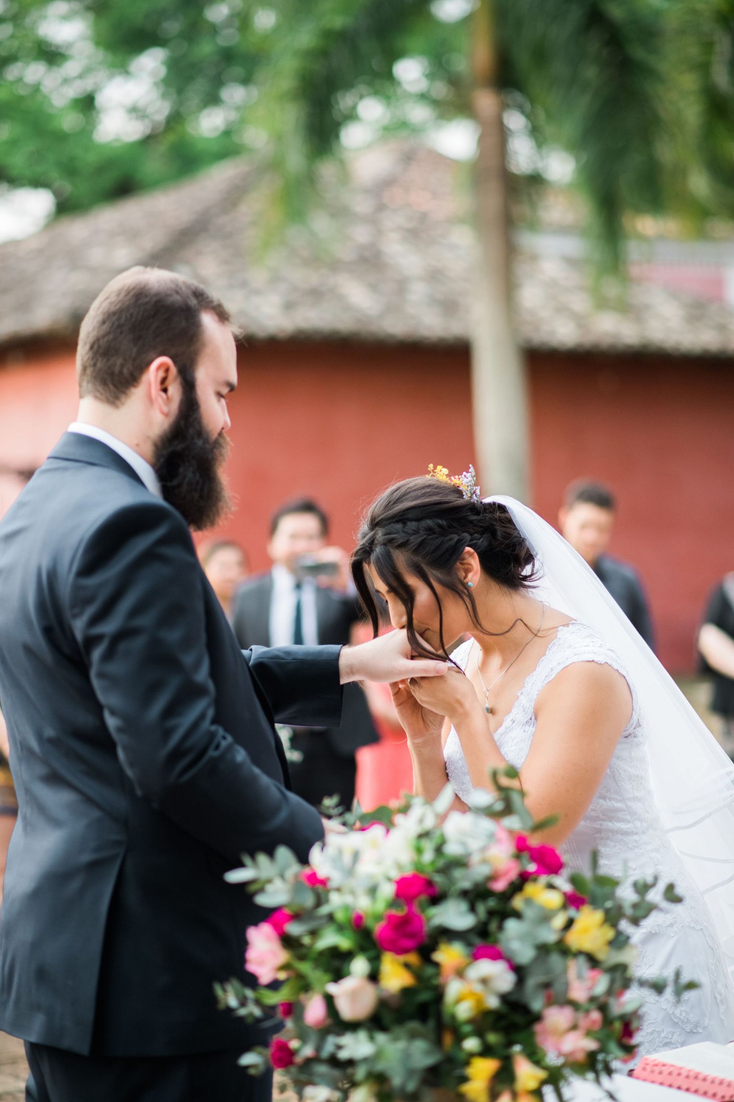 A sequence of wedding ceremony moments captured against a coral-colored wall with floral decorations.
