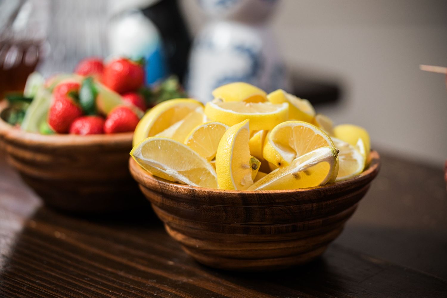 Fresh citrus slices arranged in wooden serving bowl for cocktails.