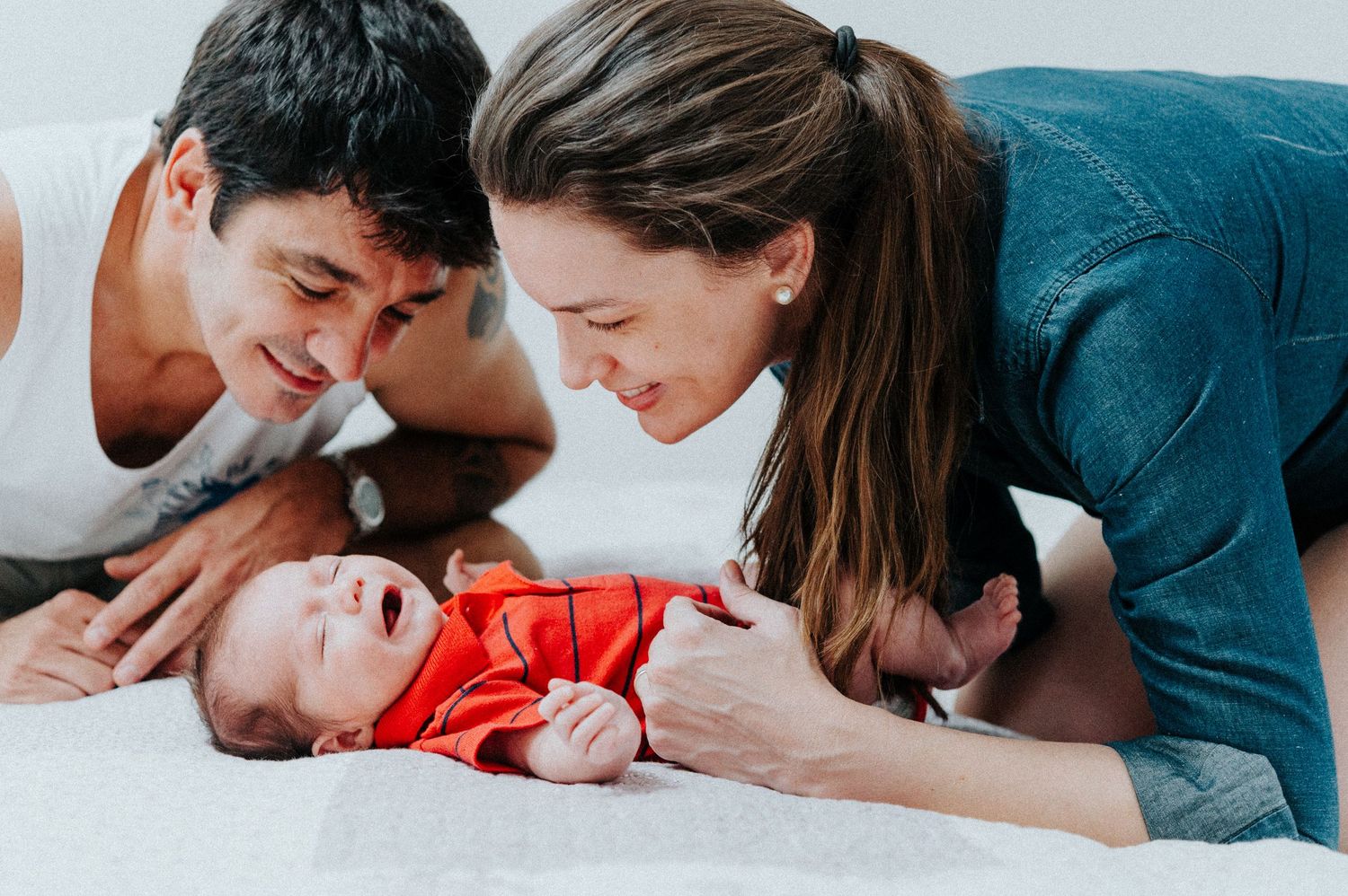 Family lying together on floor during intimate photo session.
