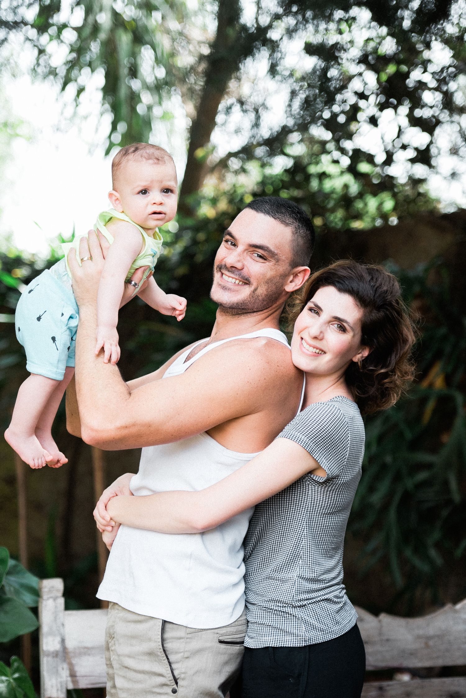 Family playtime moment captured outdoors with trees and natural lighting.