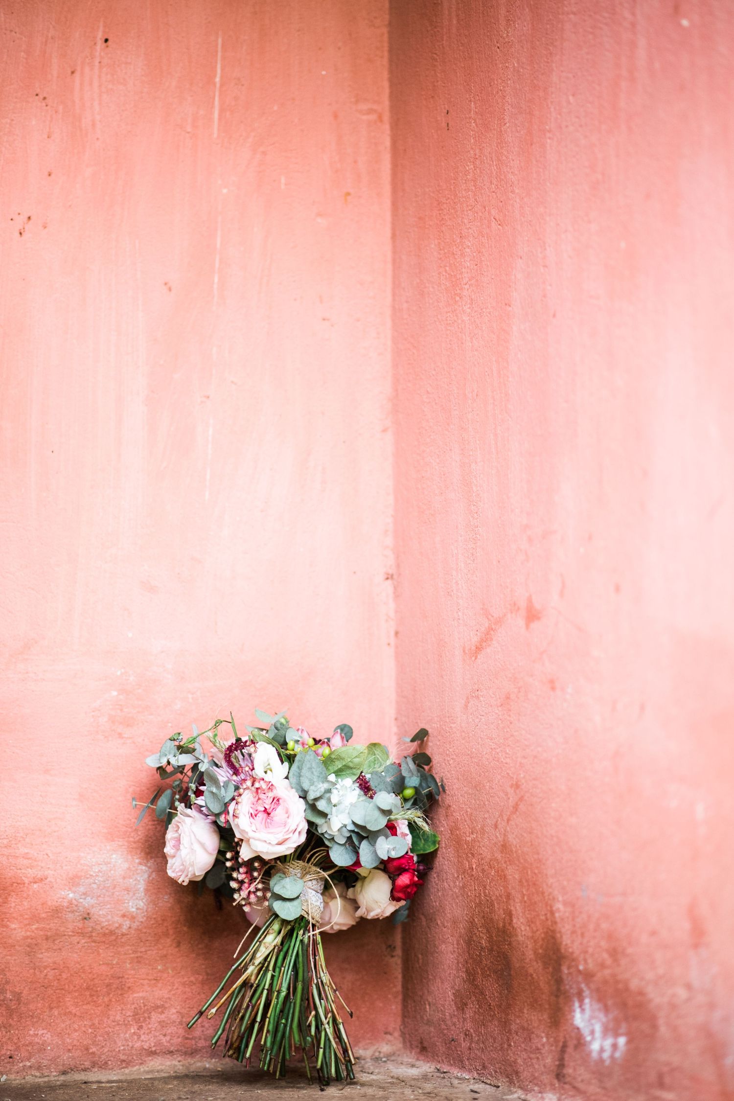 Beautiful floral bouquets arranged against a soft coral-colored wall.