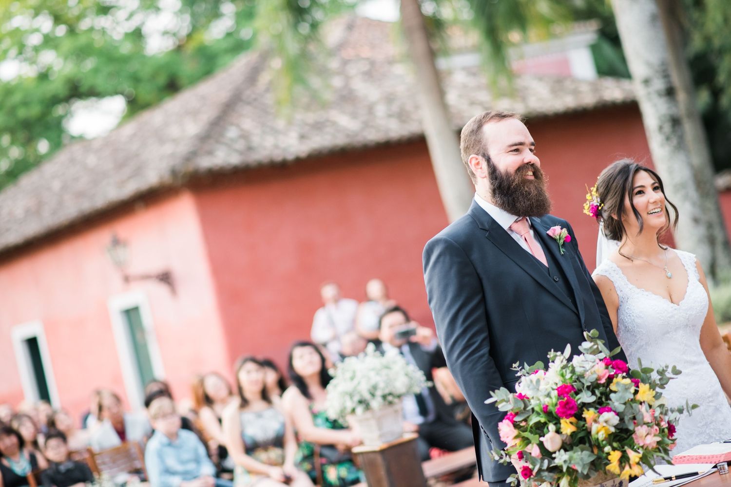 Wedding ceremony setup with floral arrangements and wooden chairs at a rustic venue.