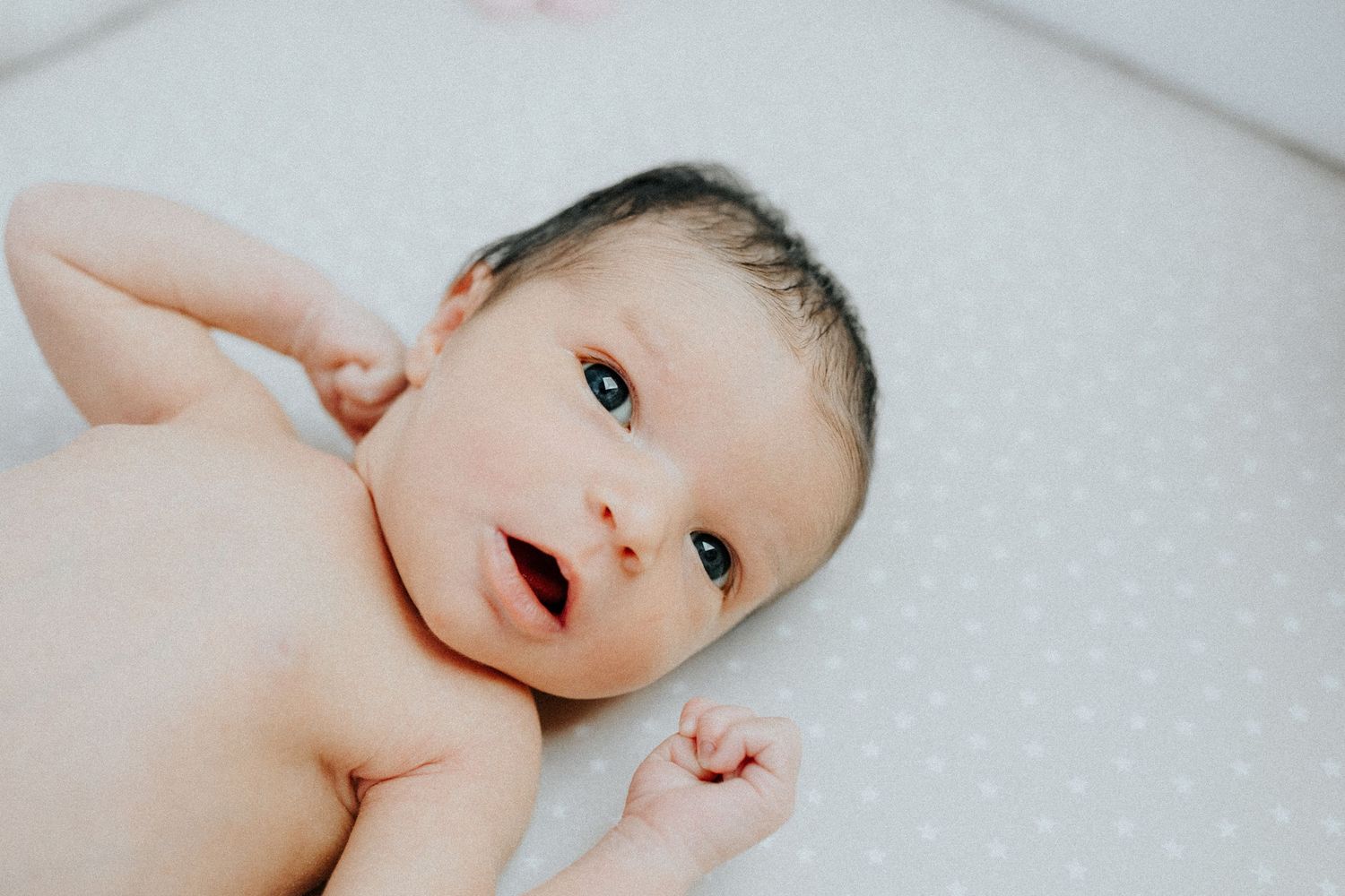 Close-up portrait series of newborn baby on polka dot blanket.