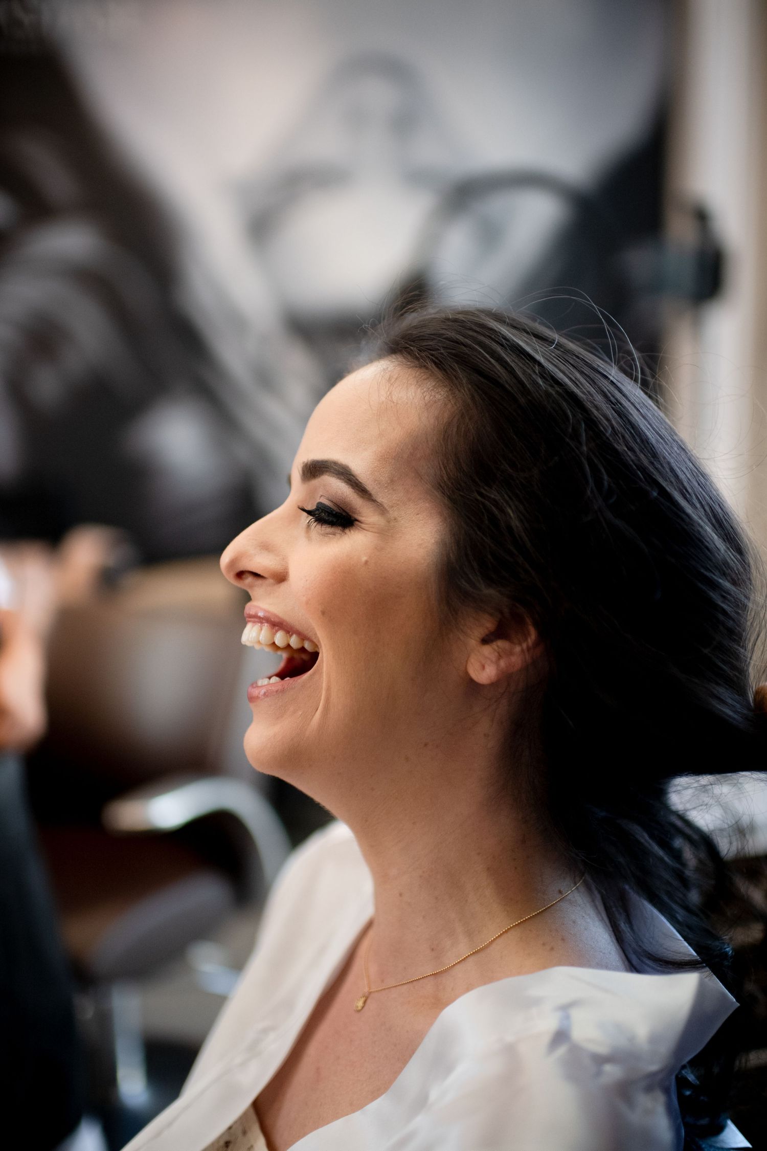 Candid moment of joyful laughter during wedding day preparations.