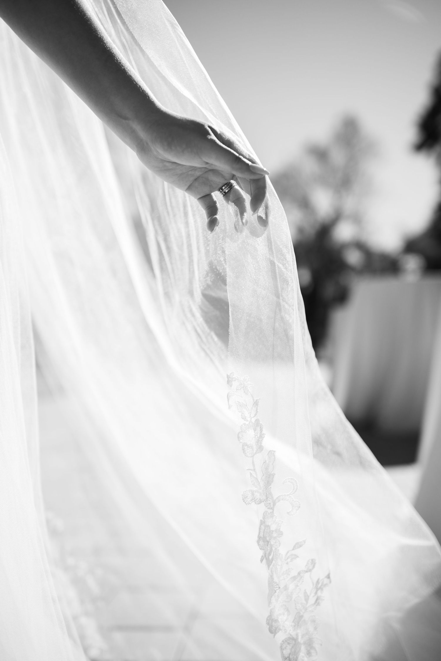 Flowing white wedding dress fabric captured in ethereal black and white photography.