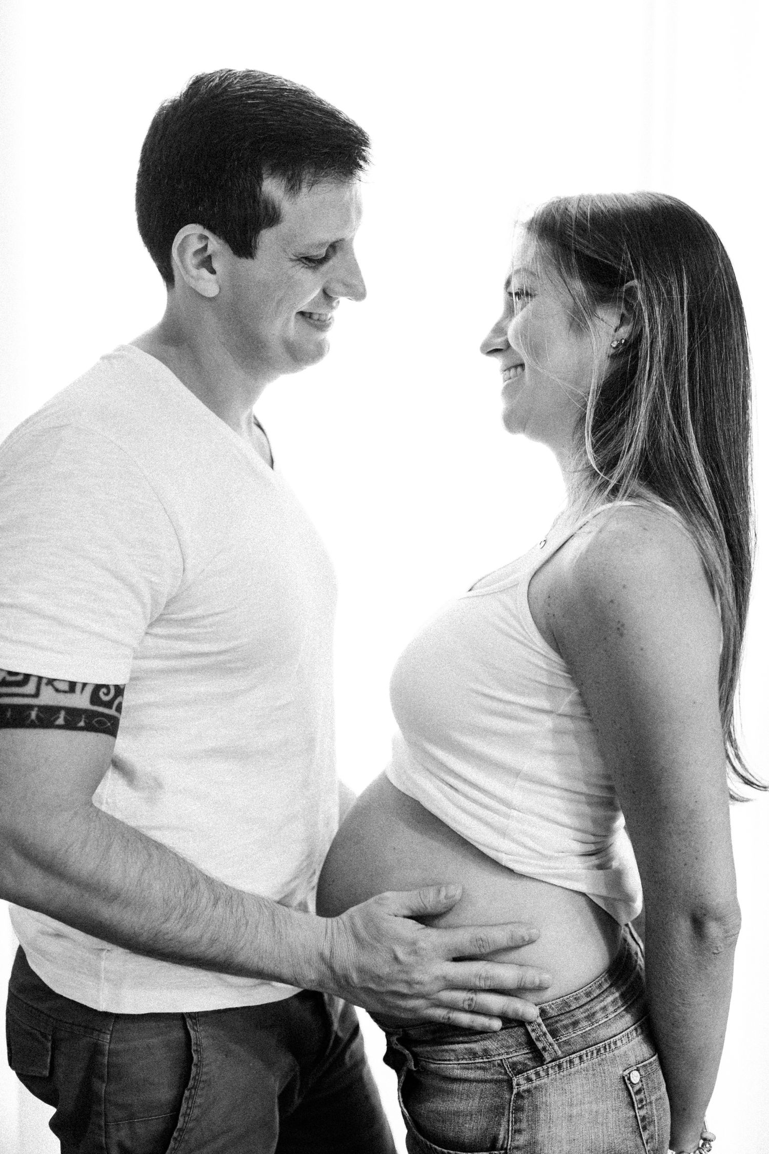 Series of candid black and white photos showing tender pregnancy moments between couple.
