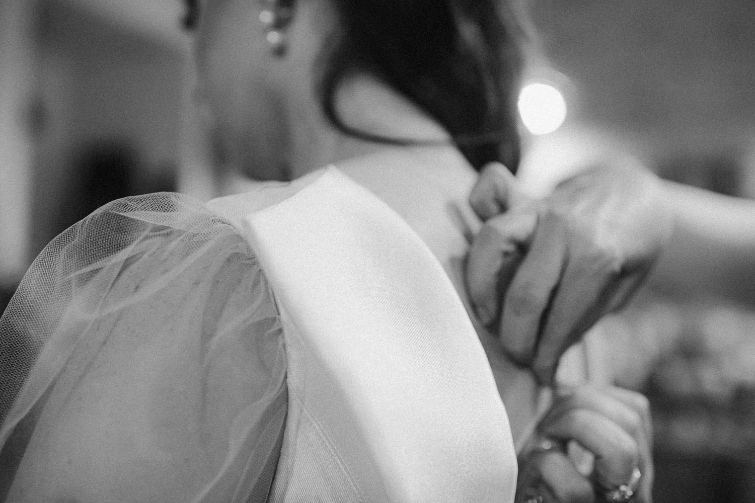 Close-up detail shot of a wedding dress and veil in black and white.