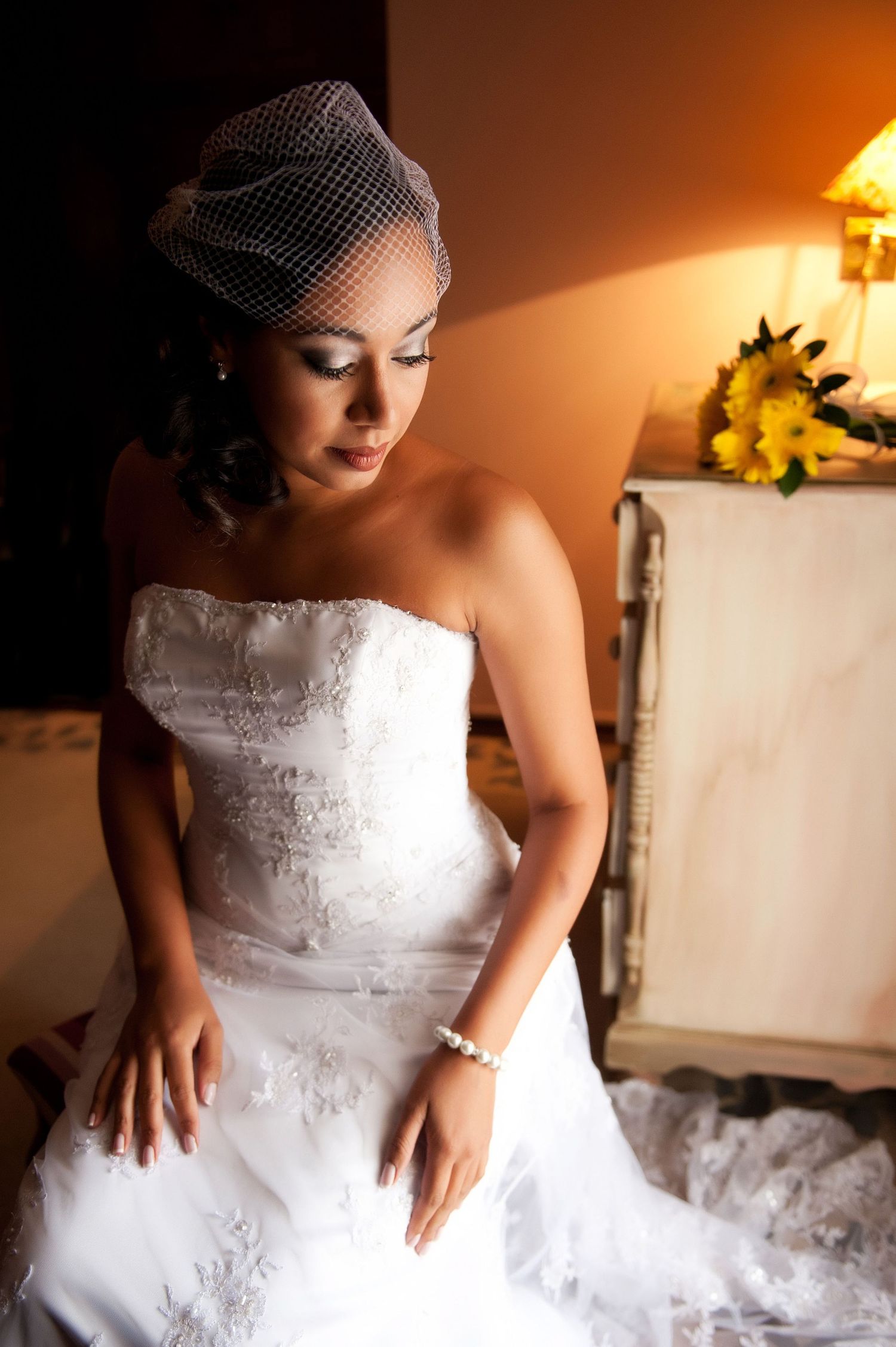 Warm-toned bridal portrait showing intricate details of wedding dress.