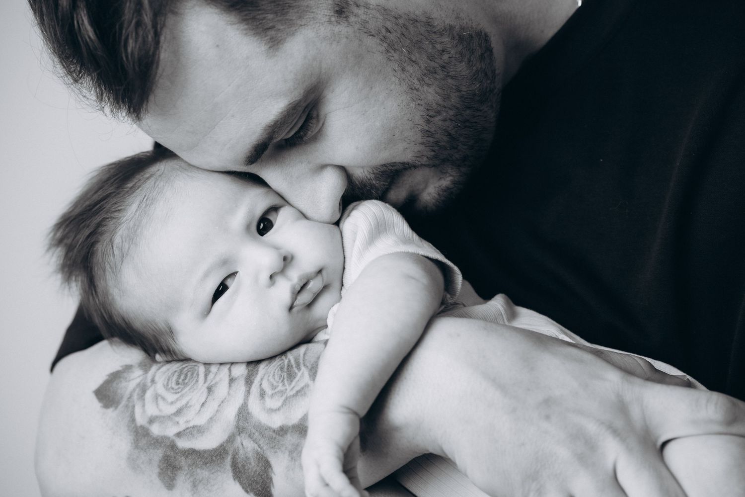 Black and white intimate portraits showing gentle moments with a baby.