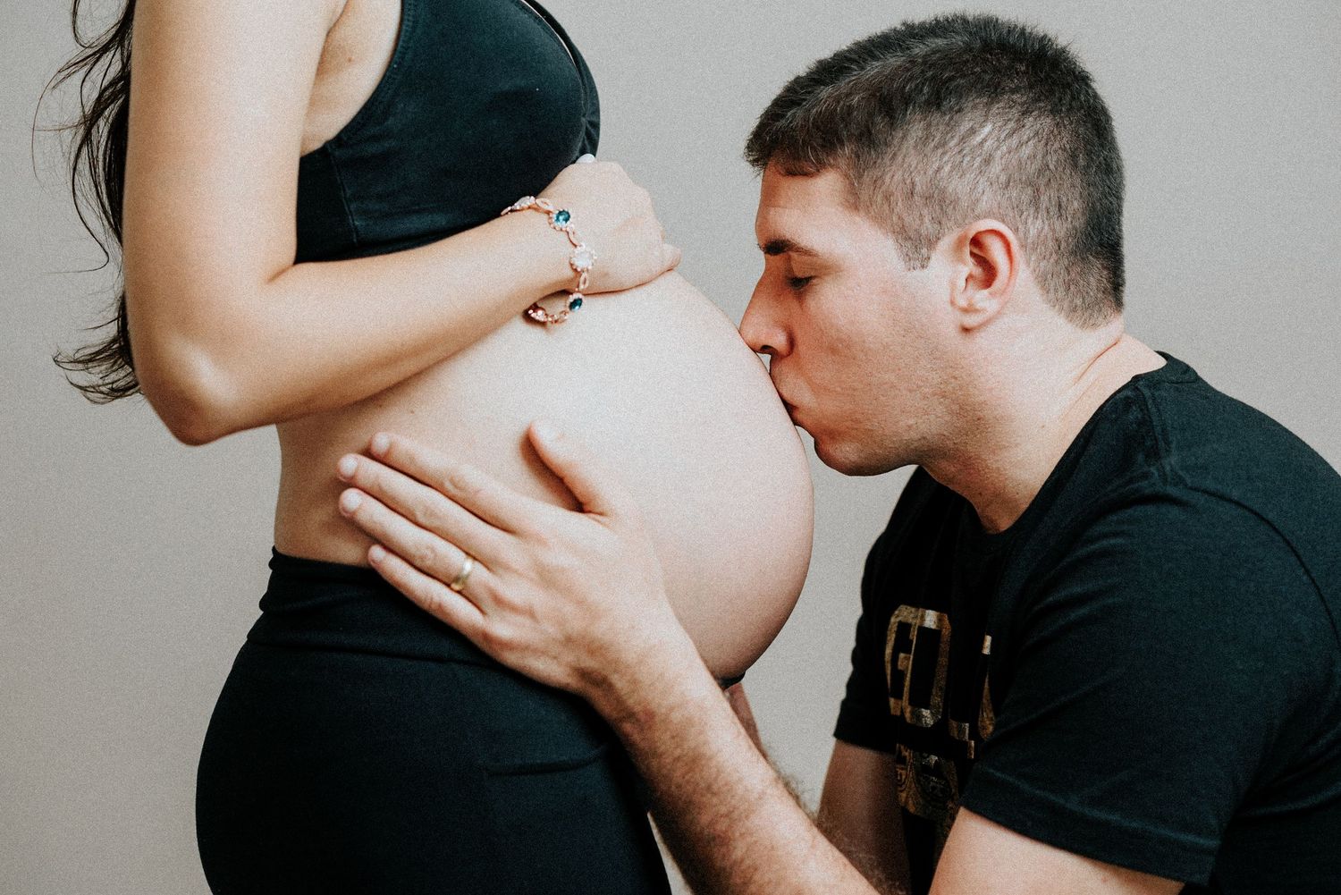 Couple shares tender moment during maternity photoshoot.