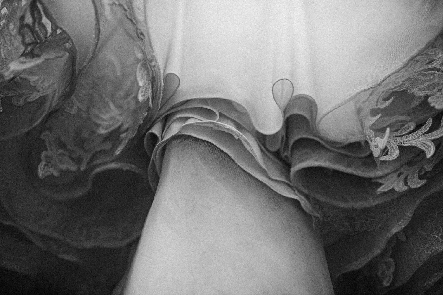 Close-up detail shot of delicate ruffled layers in a wedding dress.