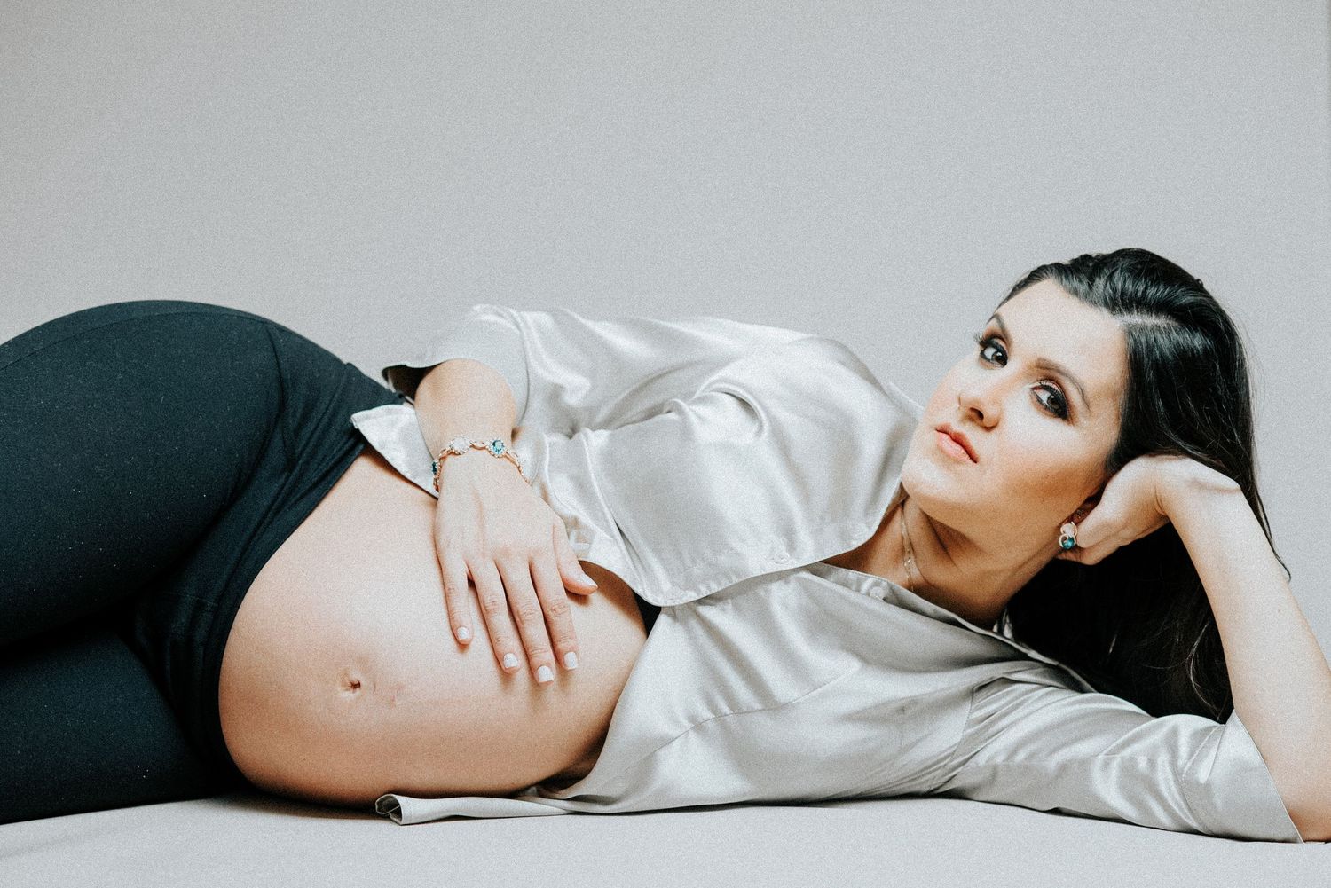Artistic maternity photo with couple in white and black clothing.