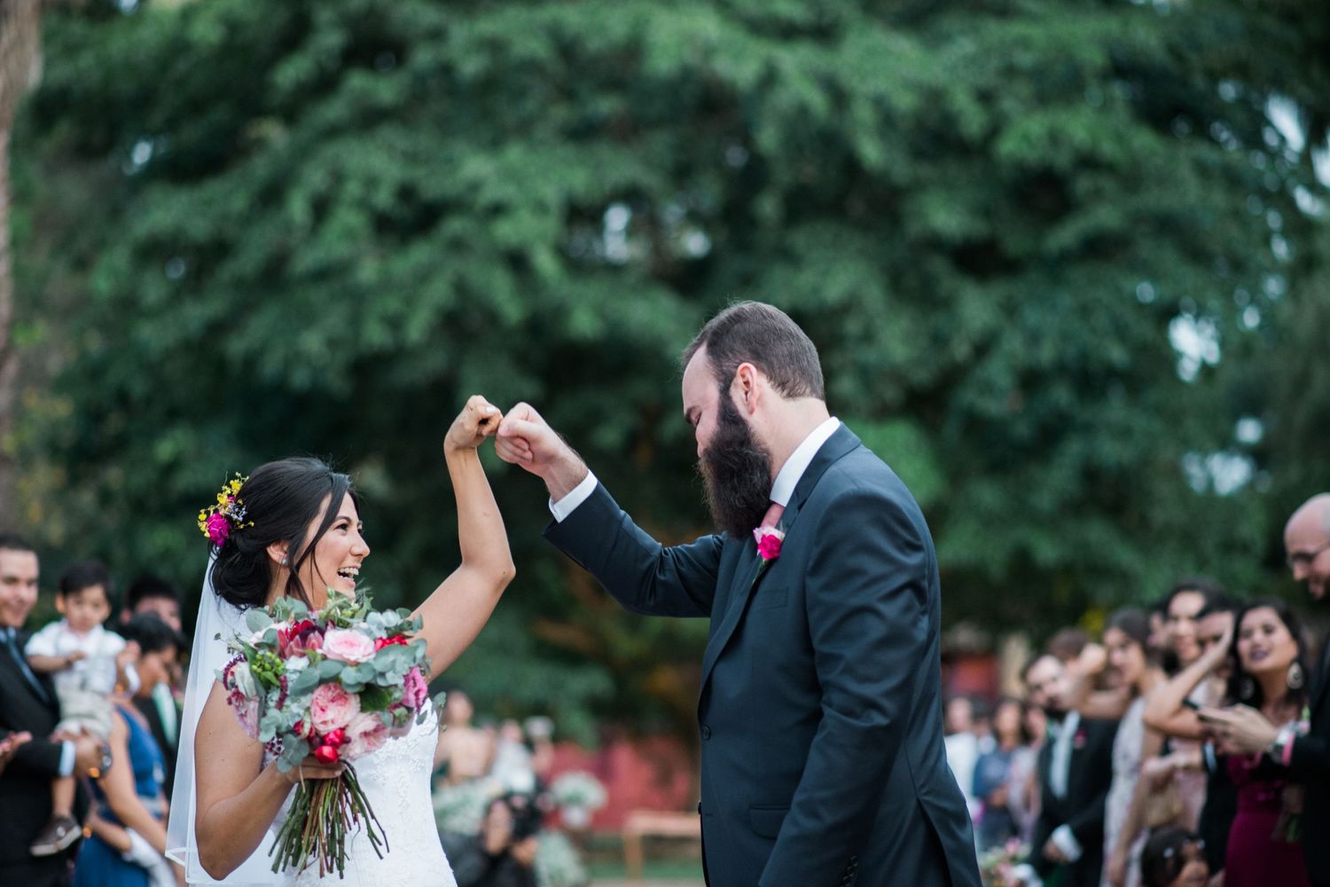 Outdoor wedding ceremony with guests watching the celebration unfold.