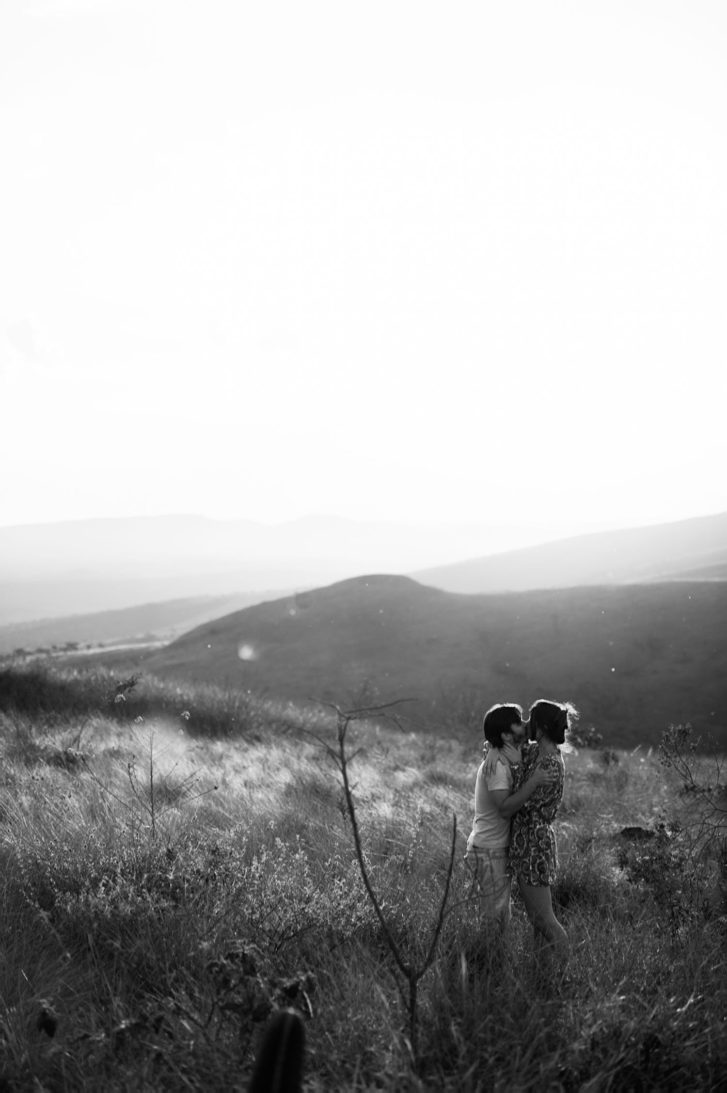 Black and white landscape sequence showing couple in mountain meadow at sunset.