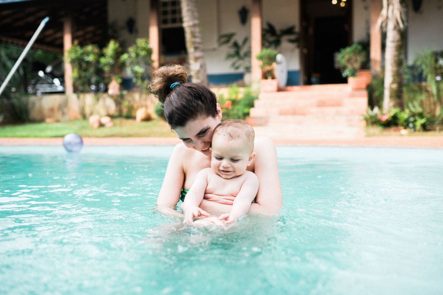 Swimming pool scene with splashing water and bright sunlight.