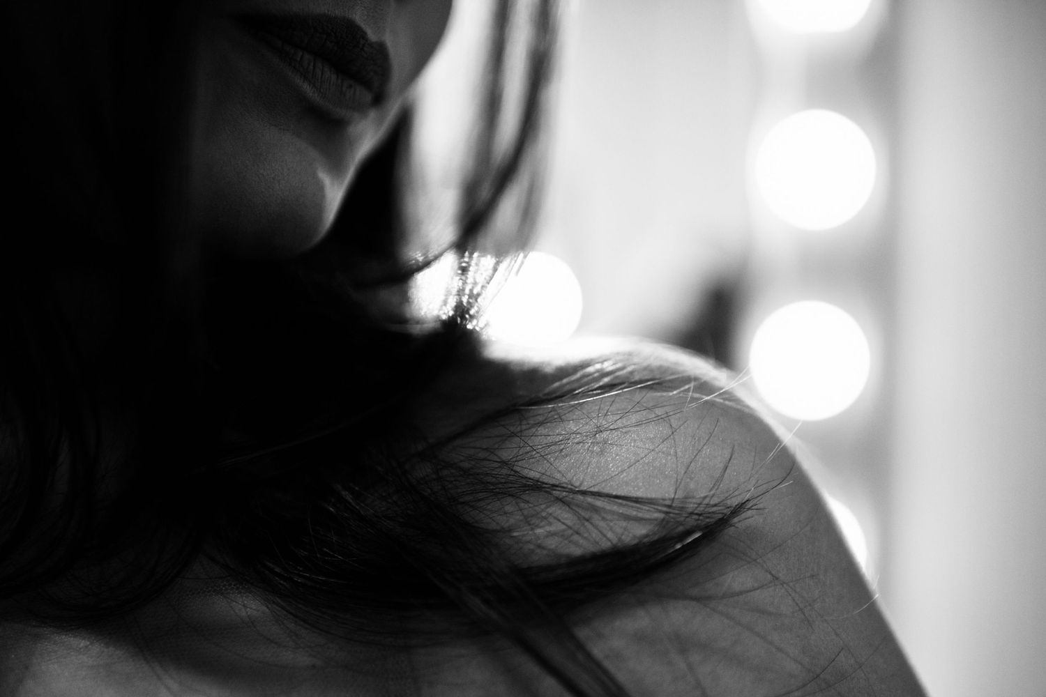Artistic black and white close-up portrait with dramatic lighting and shadows.