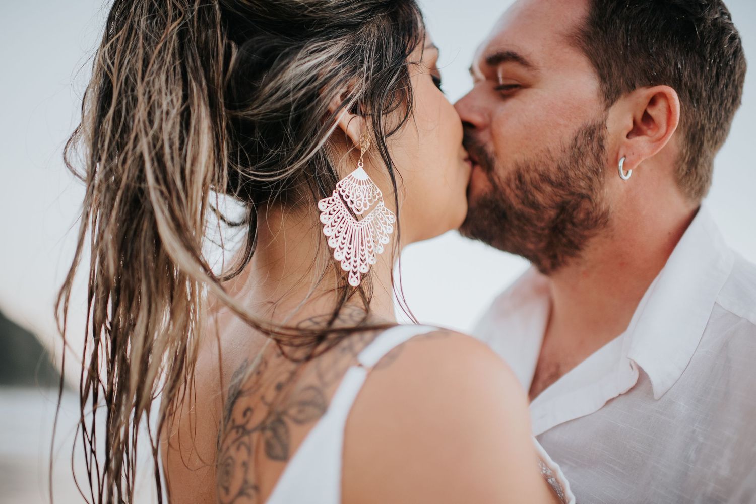 Intimate close-up of a couple sharing a tender moment on the beach.