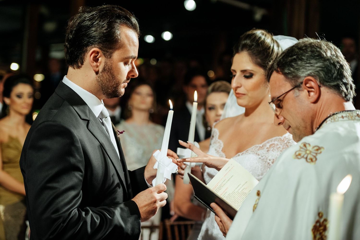 Intimate candlelit wedding ceremony moment captured in warm tones.
