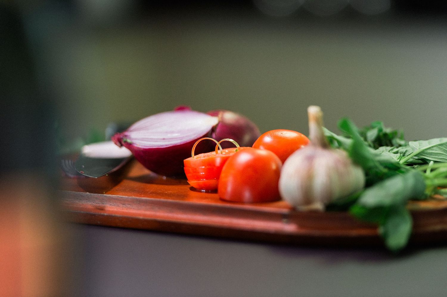 Fresh vegetables and ingredients arranged on cutting board in kitchen.