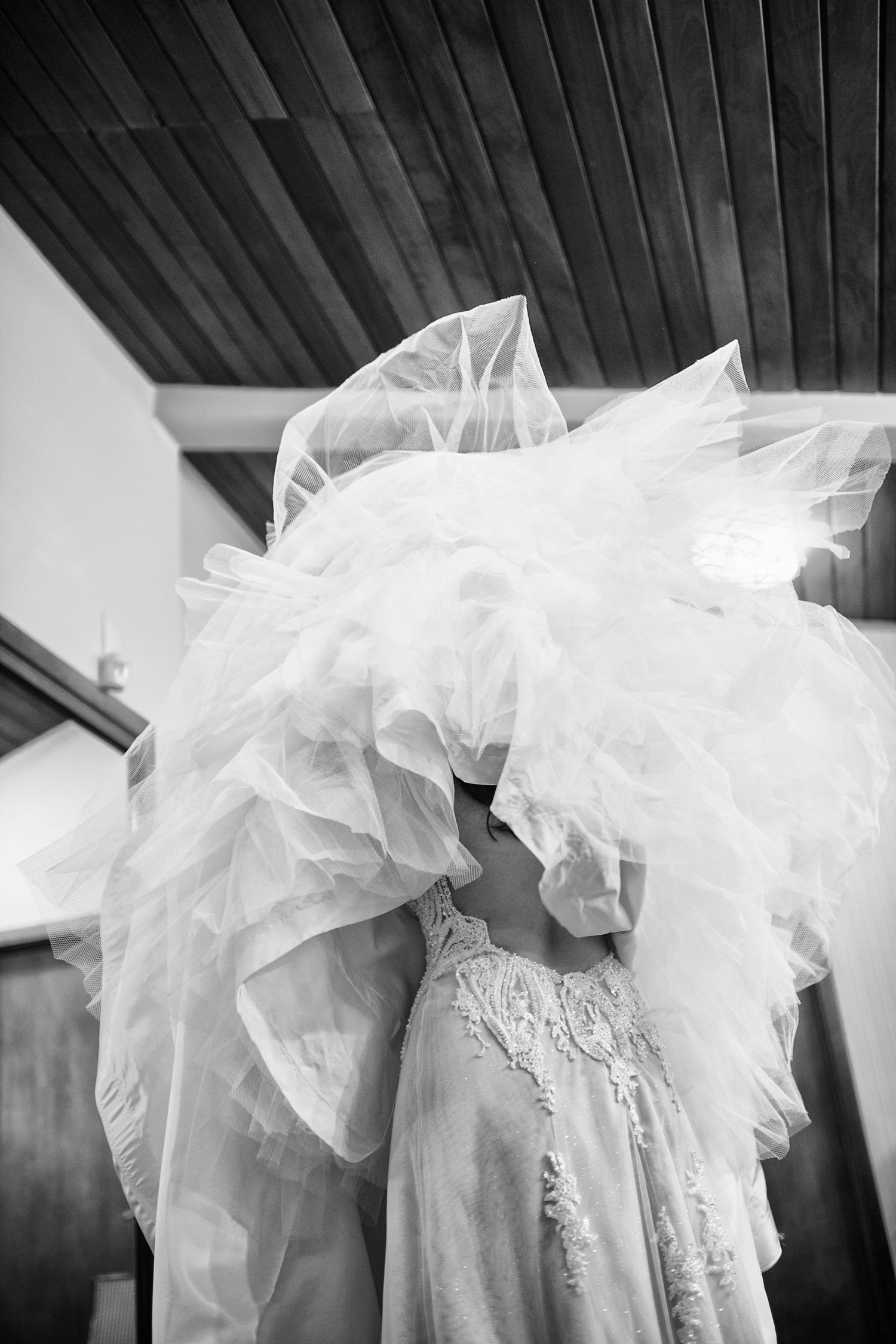 Elegant white wedding dress with intricate lace details and flowing tulle fabric.