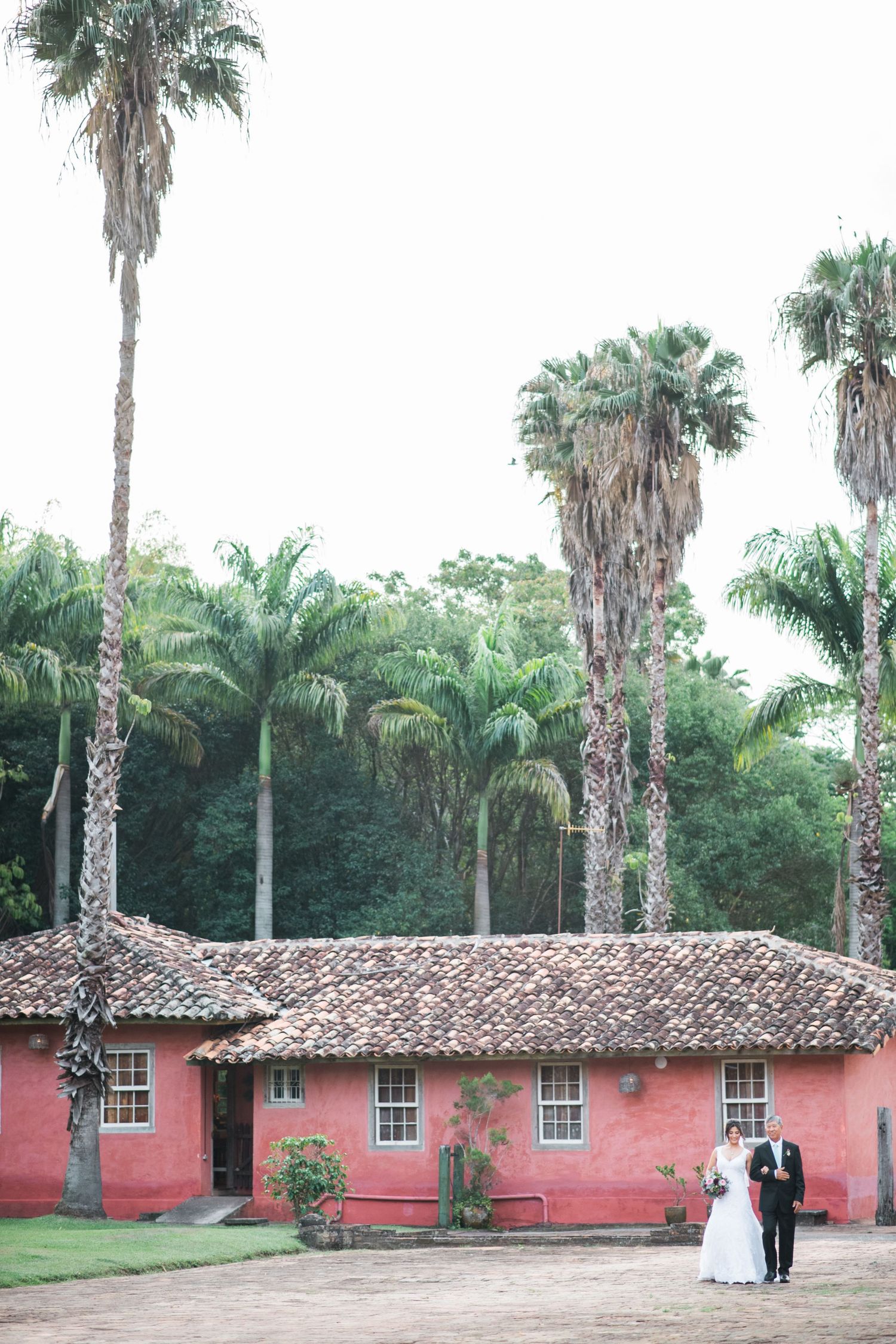 Historic pink building with palm trees and Spanish colonial architecture.
