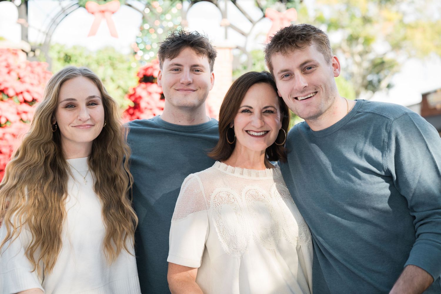 People wearing coordinated outfits pose together during a family photo session.