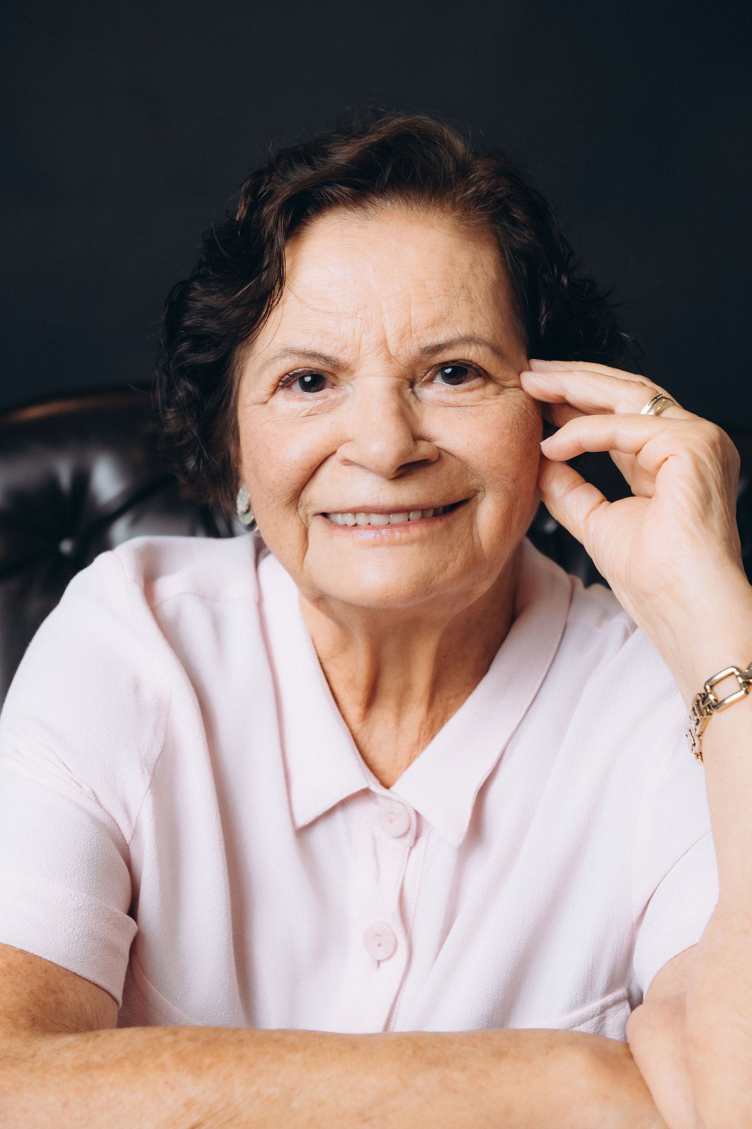 Expressive portrait series showing warm smiles while wearing a pink collared shirt.