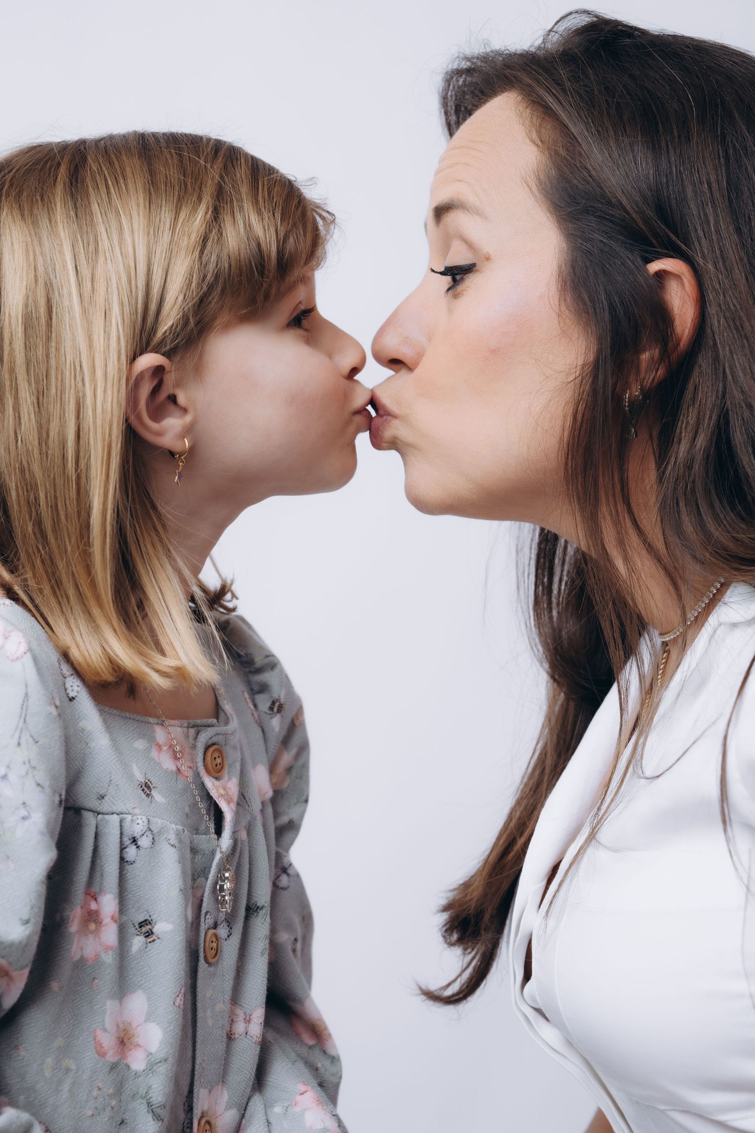 Intimate mother and daughter nose-touching moments captured in studio portraits.