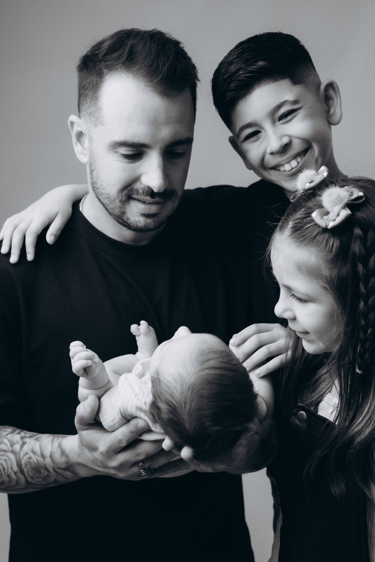 Black and white photo series showing tender family moments with a newborn baby.