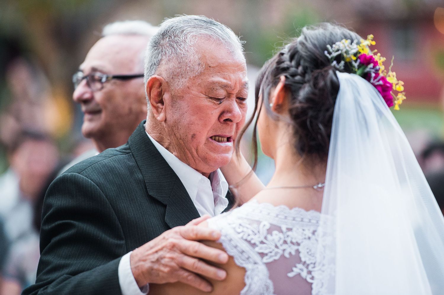 A joyful wedding ceremony moment captured outdoors with guests looking on.