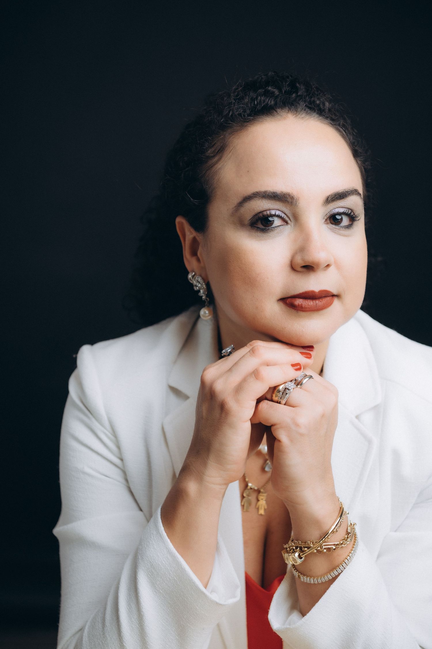 Elegant professional portraits featuring white blazer and statement jewelry.