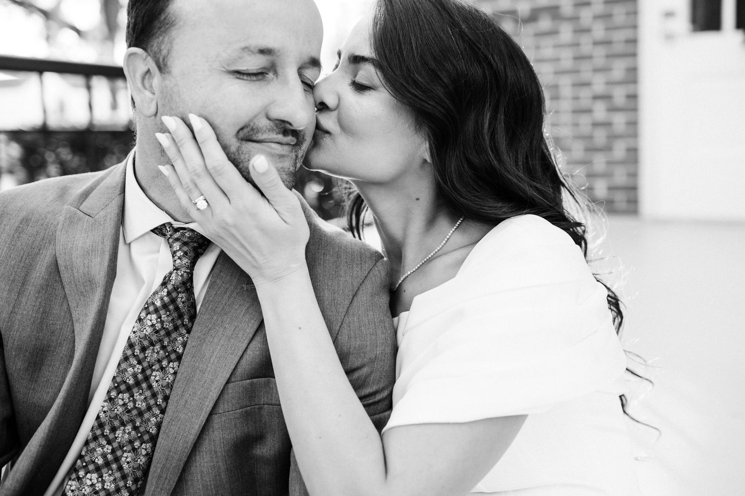 A romantic black and white portrait of a couple sharing a tender moment.