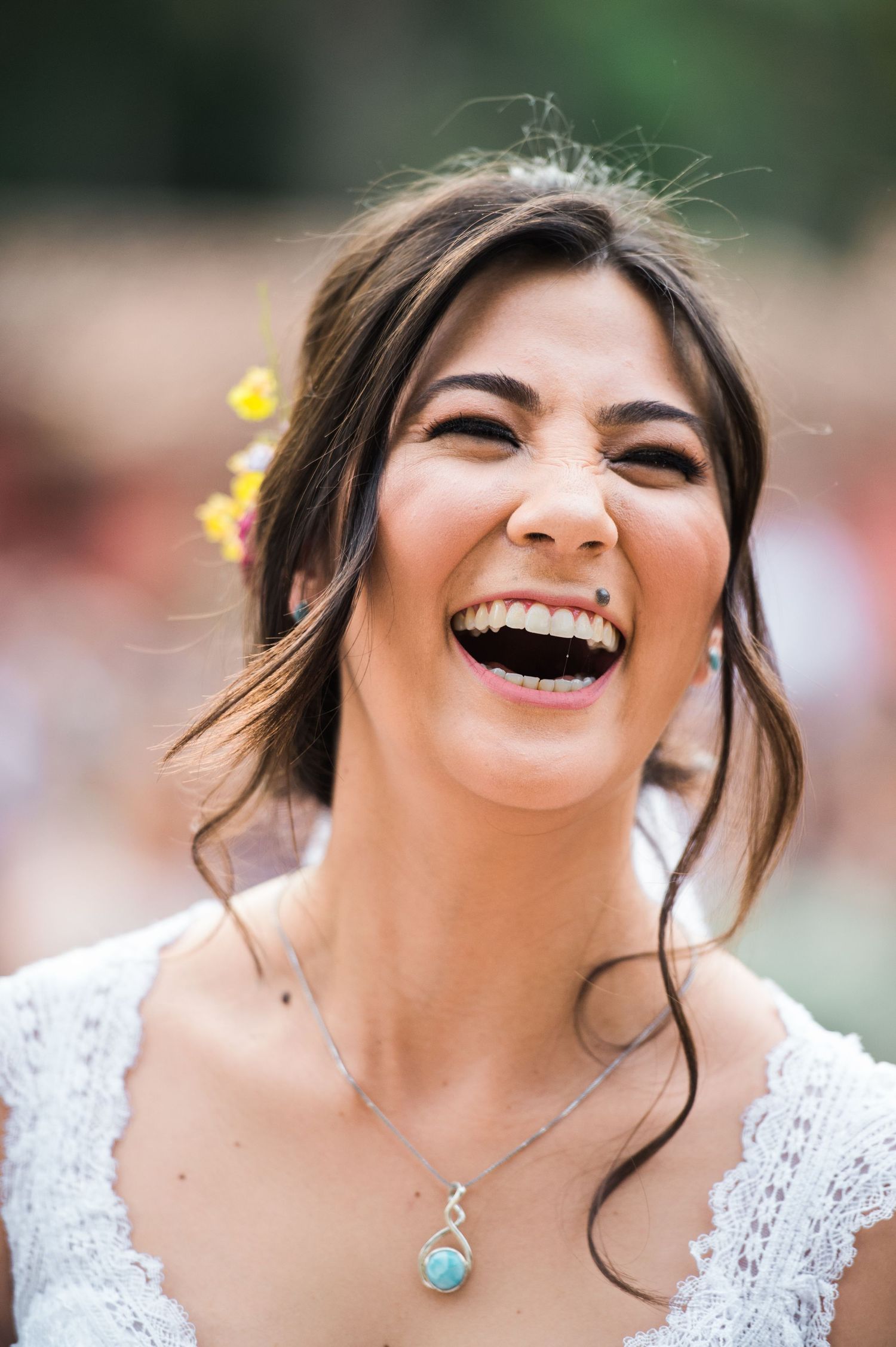Close-up sequence of a joyful laugh in white lace dress with delicate floral hair accessories.