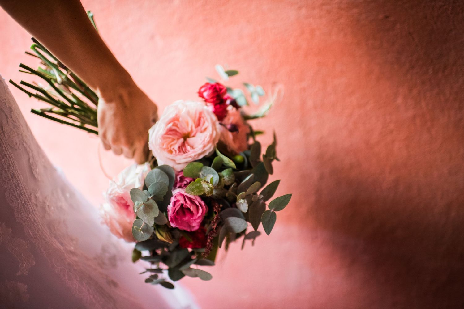 Pink and red floral arrangements against a coral-colored background.