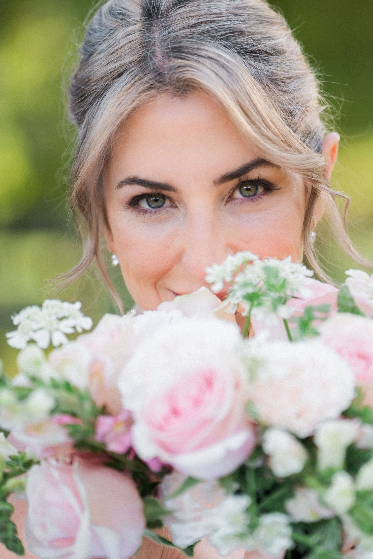 Artistic close-up of pink and white wedding bouquet with soft focus floral details.