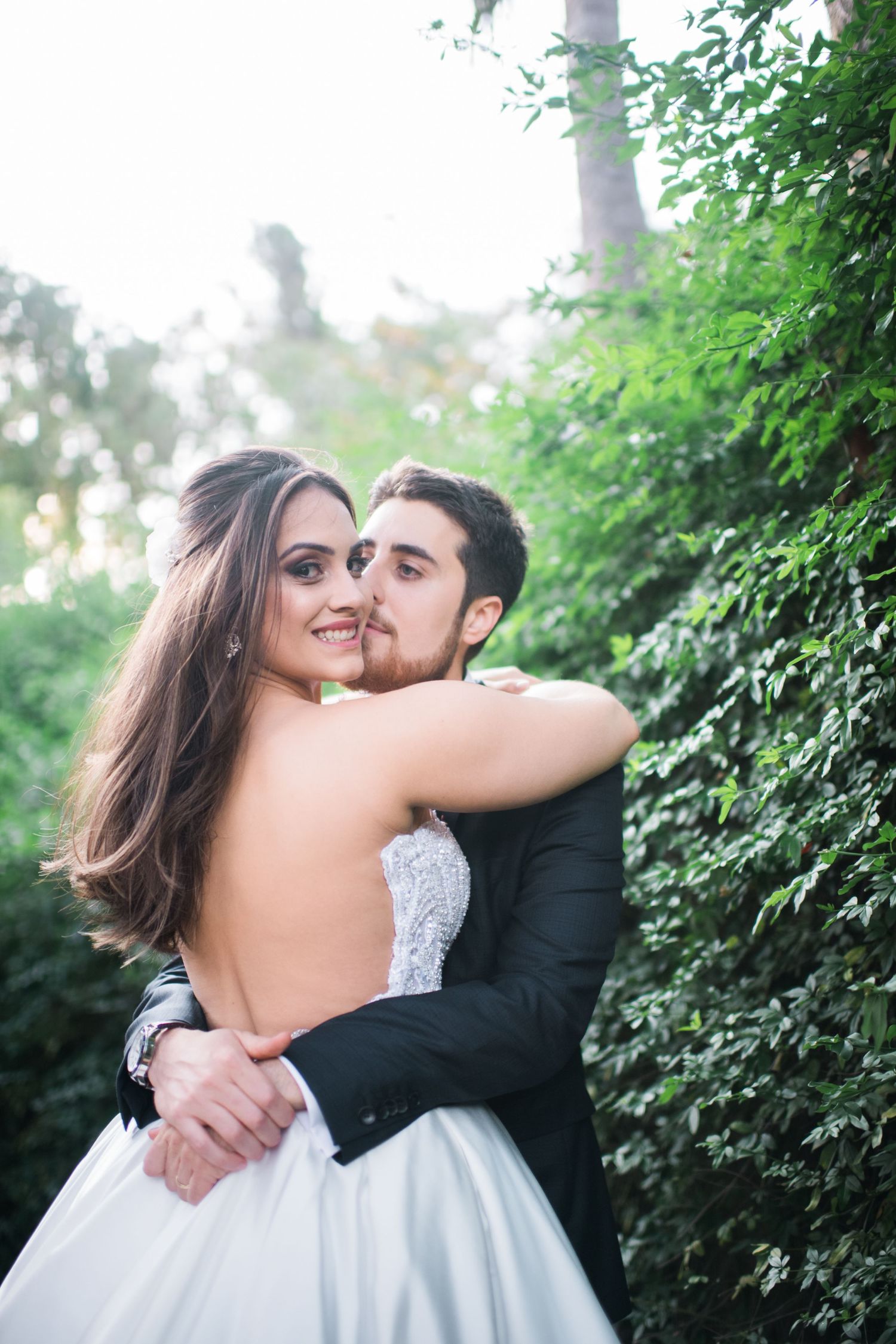 Intimate wedding portraits captured in a garden with soft natural lighting.