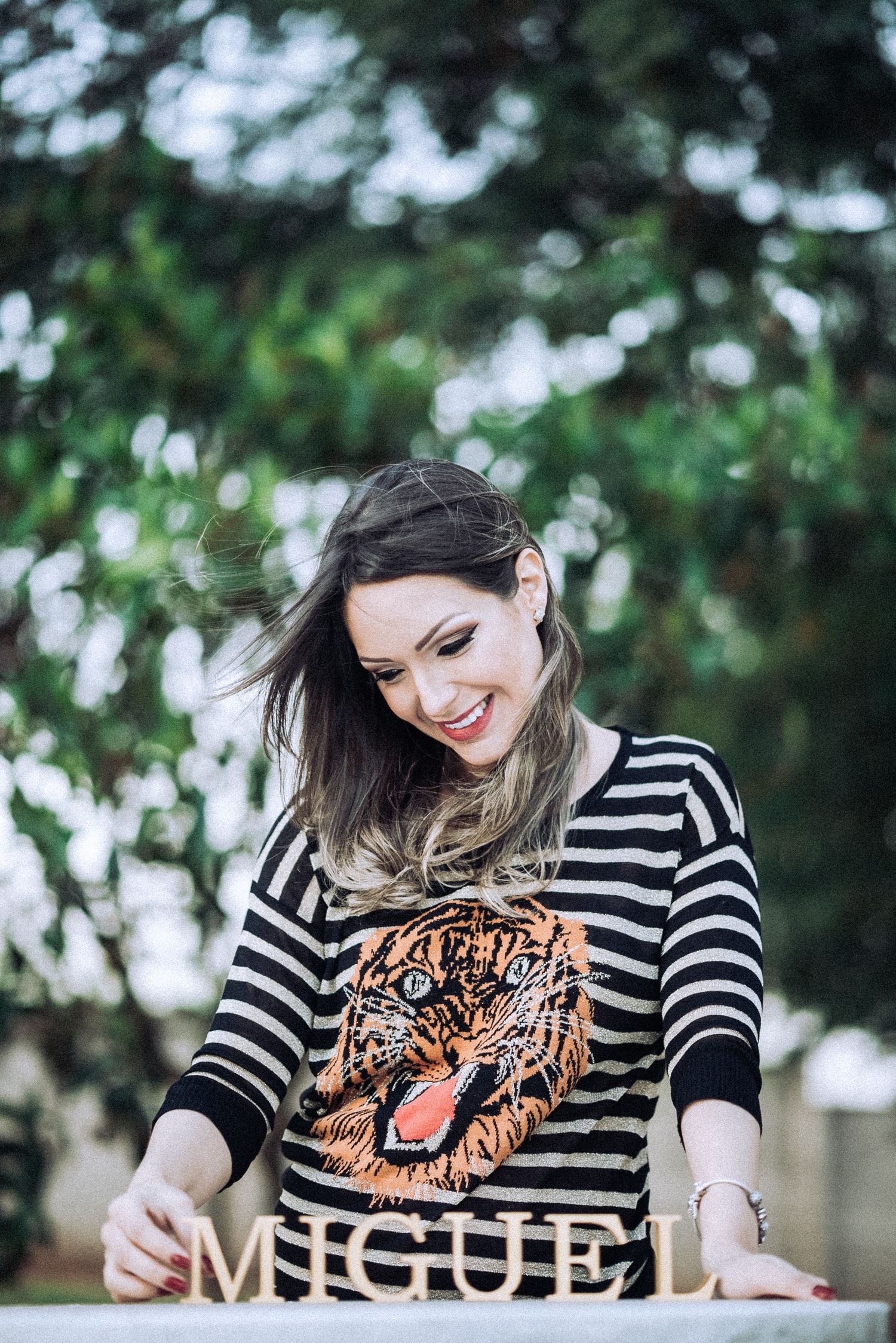 Woman wearing striped tiger print sweater during casual outdoor photo session.