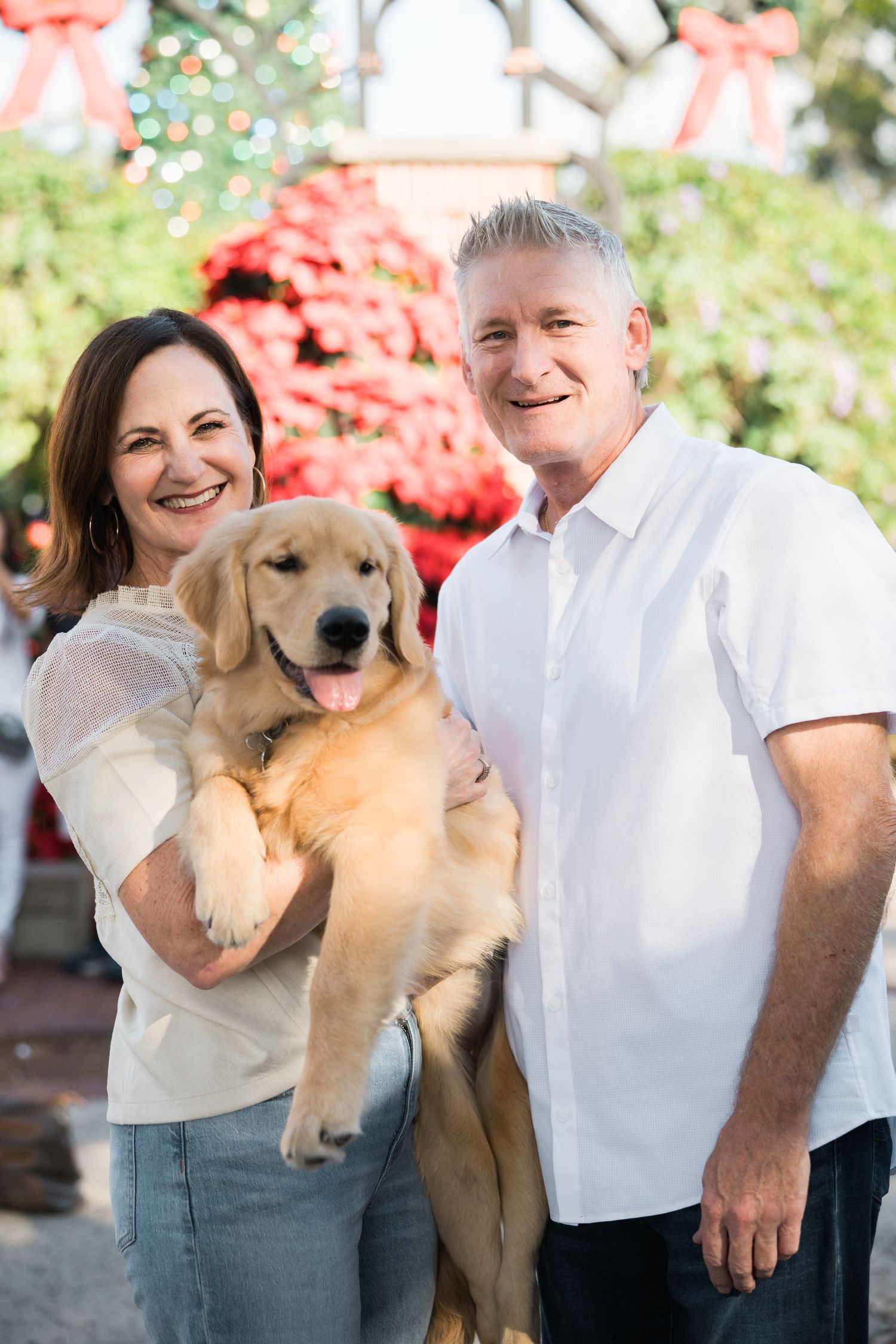 A happy golden retriever puppy joins a casual outdoor family photoshoot.