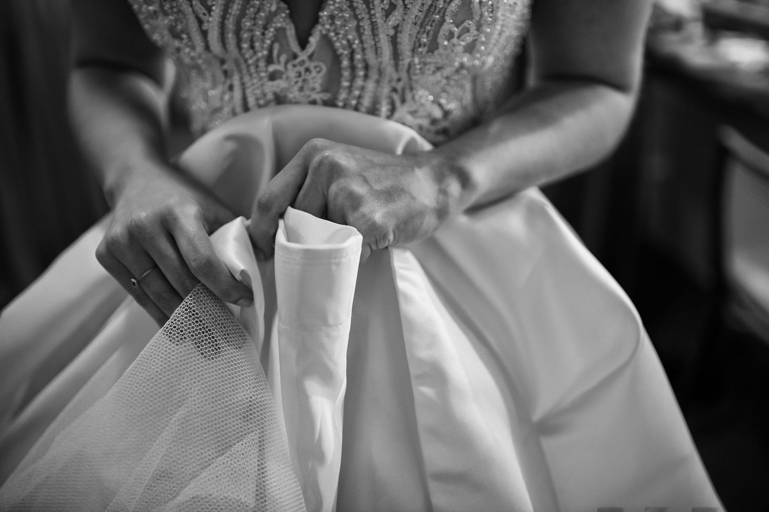 Close-up detail of an ornate beaded wedding dress bodice in black and white.