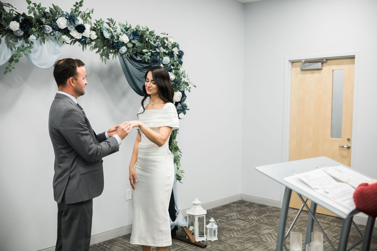 A couple celebrates during their wedding ceremony in a modern office setting.