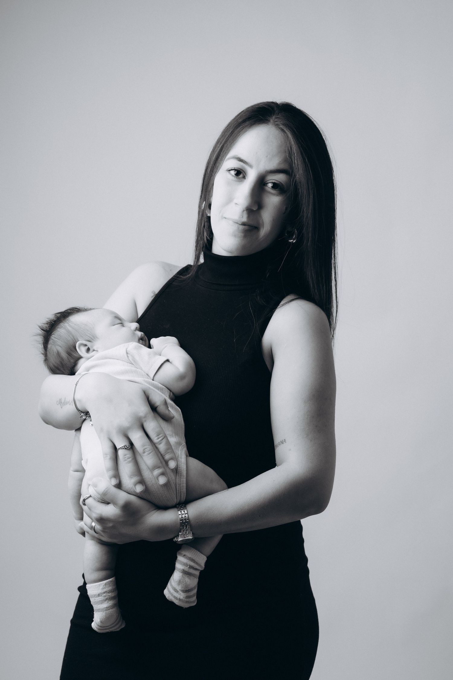 Series of black and white portraits showing a woman holding a baby in different poses.