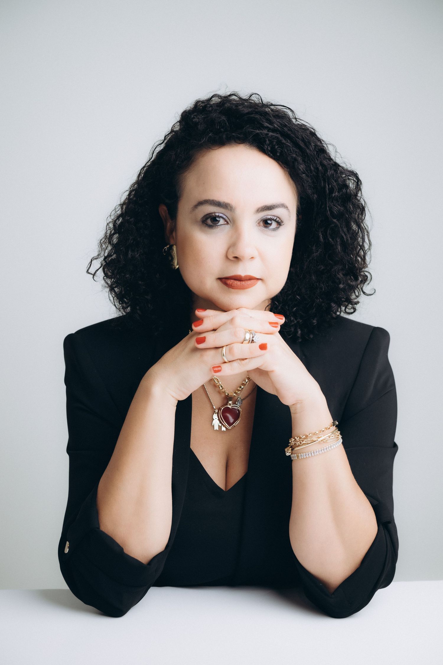 Professional headshots against white background featuring black outfit and jewelry.