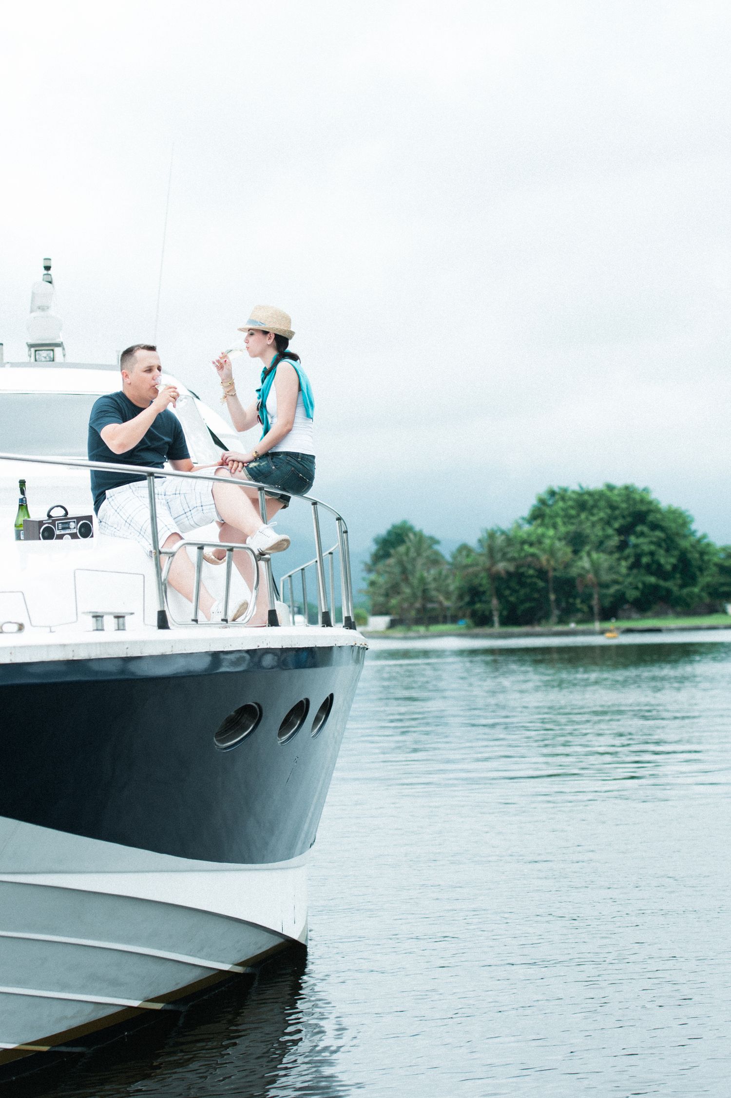 Couple enjoying a relaxing day on a boat in calm waters surrounded by lush greenery.