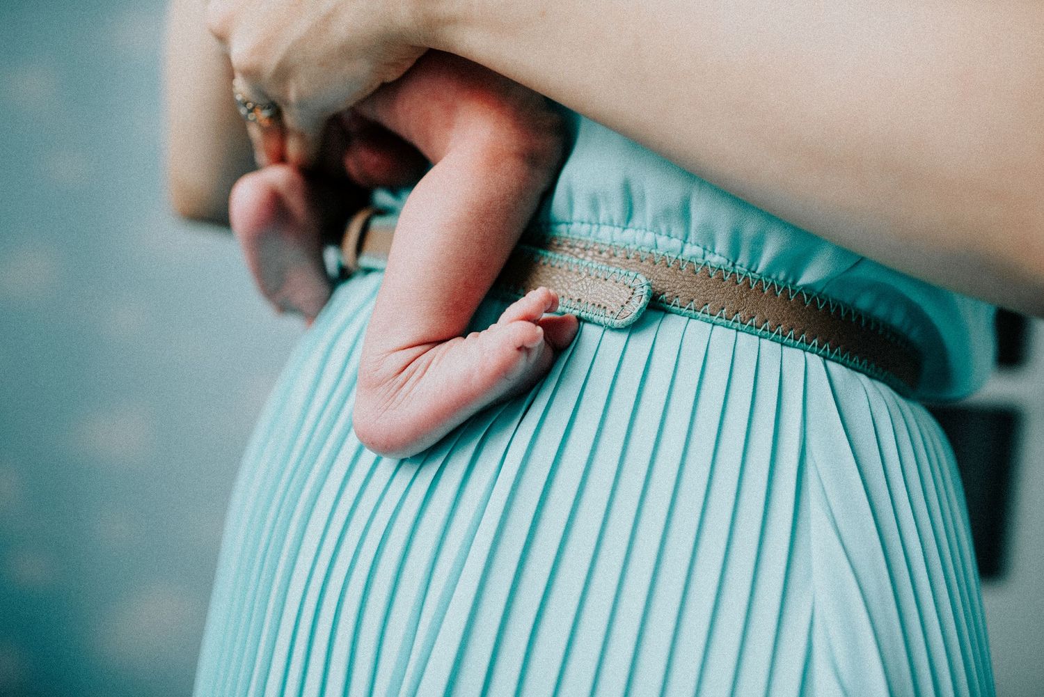 Detail shot of pleated mint green maternity dress fabric.