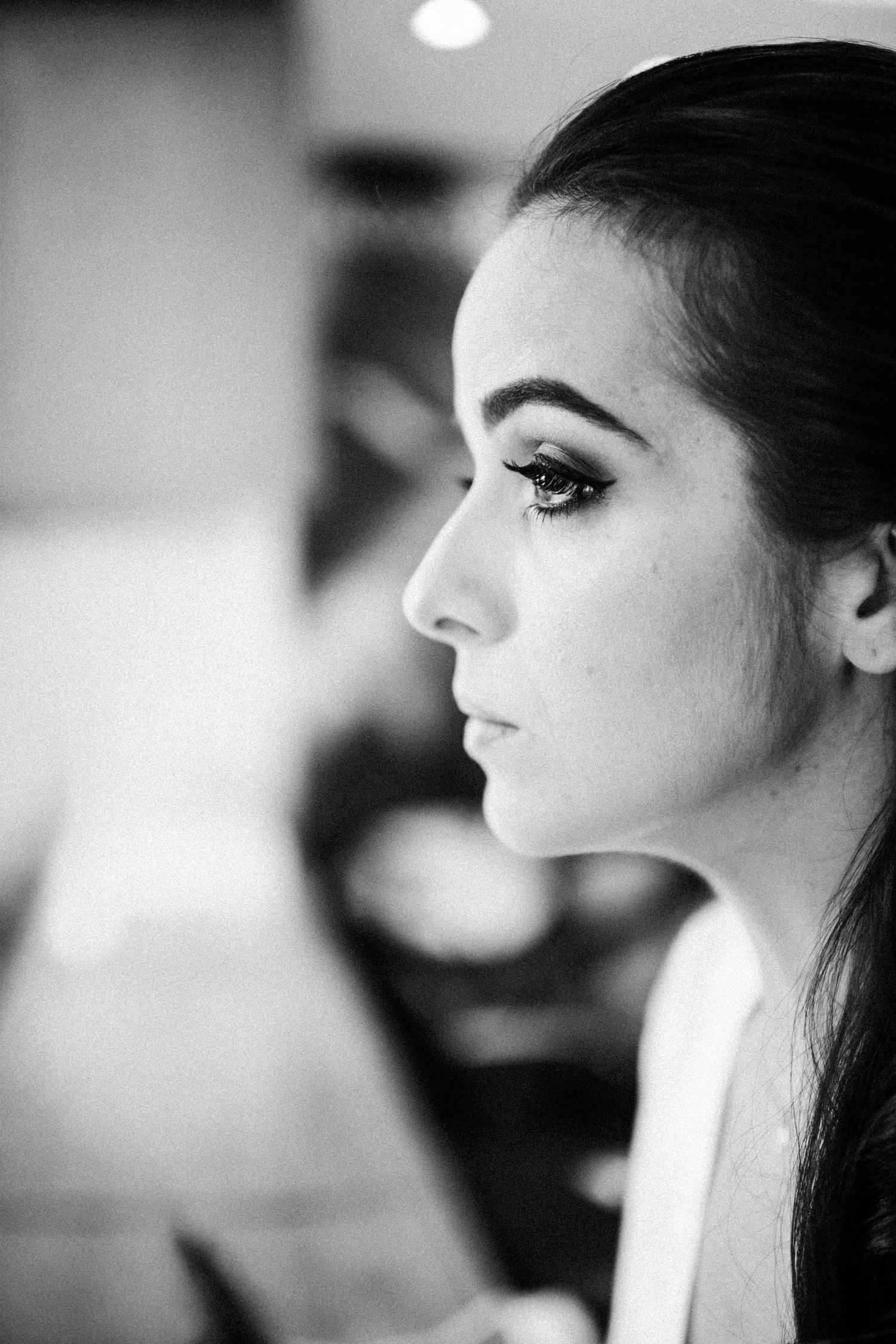 Black and white profile portraits showing elegant wedding day makeup and hair.