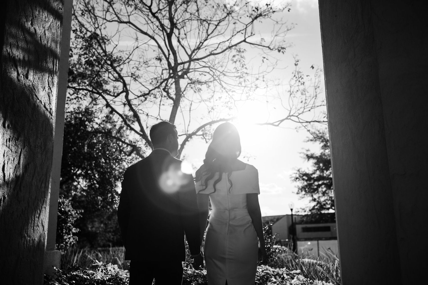 Backlit silhouettes create romantic scene against evening sky and columns.