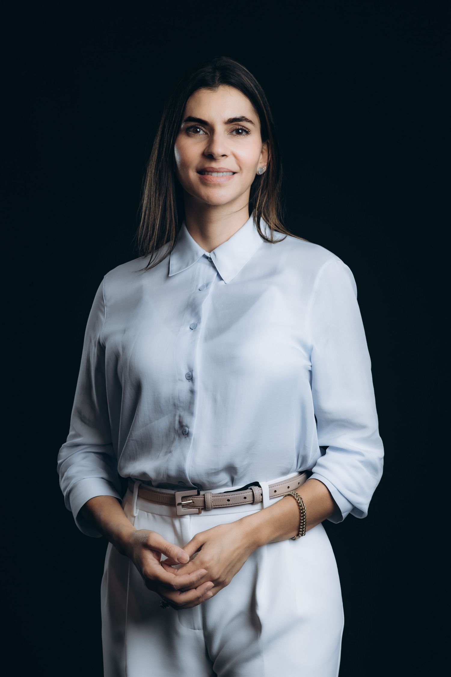 Professional studio portraits of someone wearing a crisp white button-down shirt against a dark background.