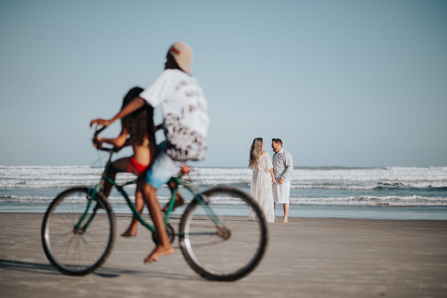 People cycling and walking along a scenic beach boardwalk.