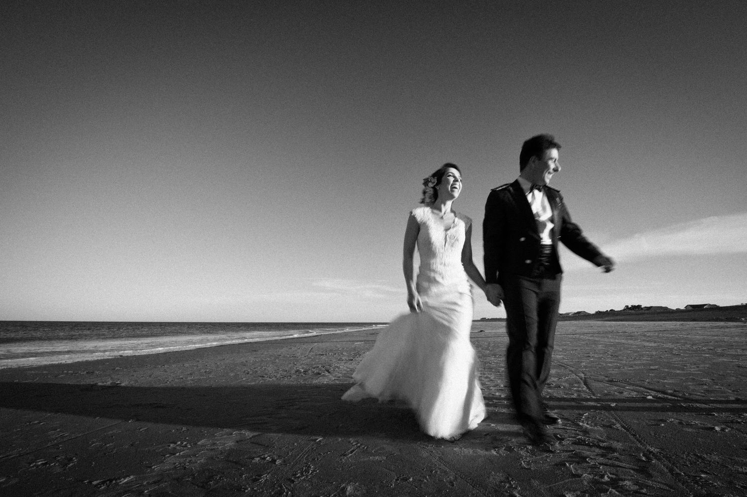 Dramatic black and white landscape wedding portraits with silhouettes against the horizon.
